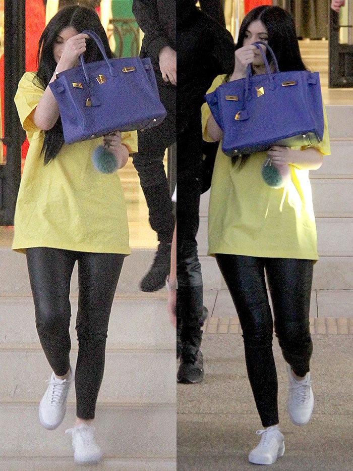 Kylie Jenner wears a yellow Supreme t-shirt and carries a blue Birkin bag