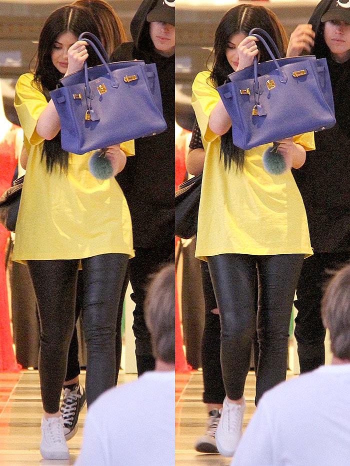 Kylie Jenner hides behind a large blue Birkin bag during a shopping trip