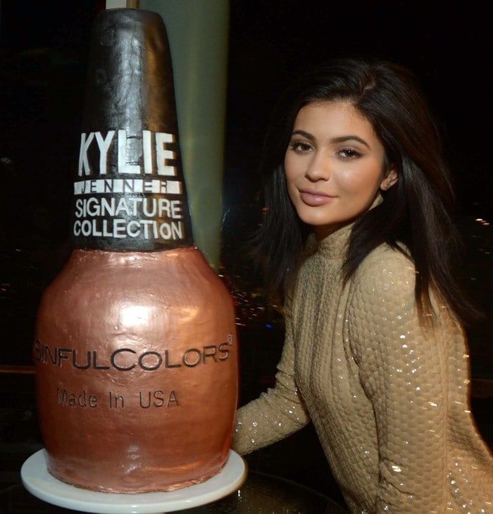 Kylie Jenner poses with a cake fashioned after her new shade of nail polish