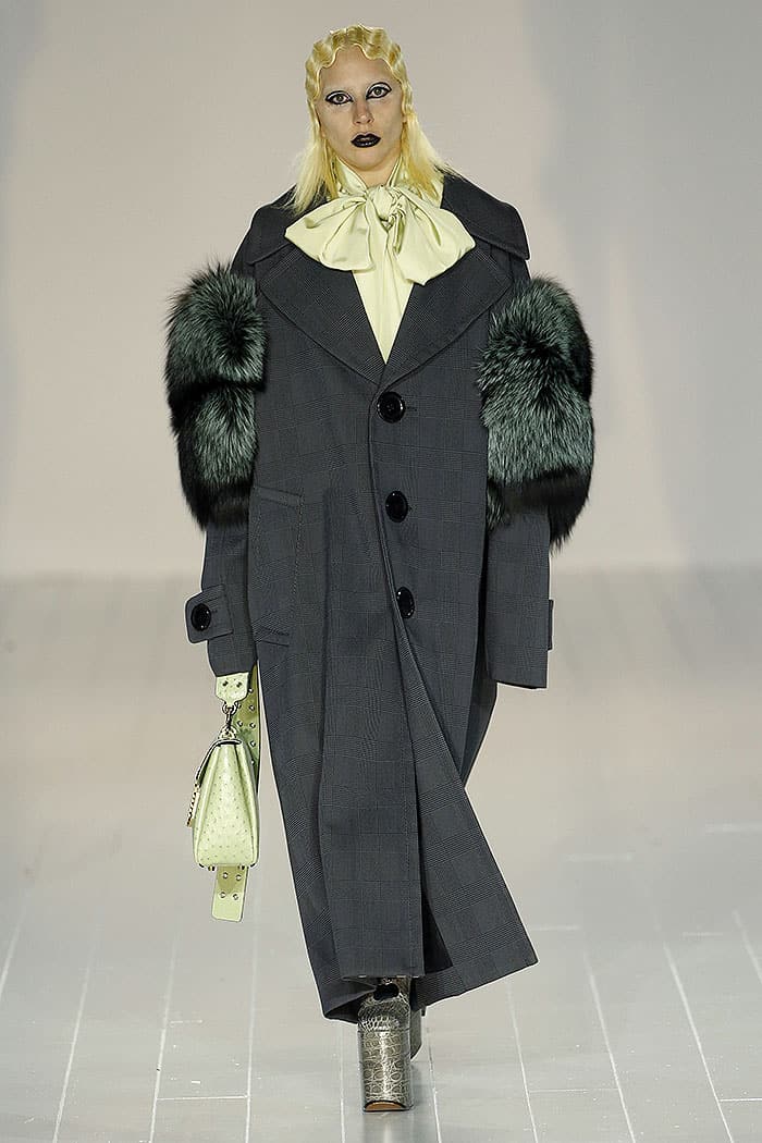 Lady Gaga showcased look number 20, which consisted of a grey oversized coat with teal green fur puff sleeves, and a pussy bow blouse