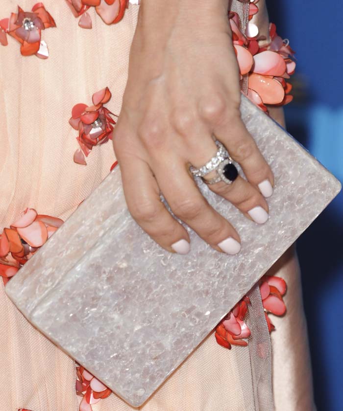Mena Suvari complements her floral-embellished dress with a chic rectangular Edie Parker clutch and a sophisticated nude manicure