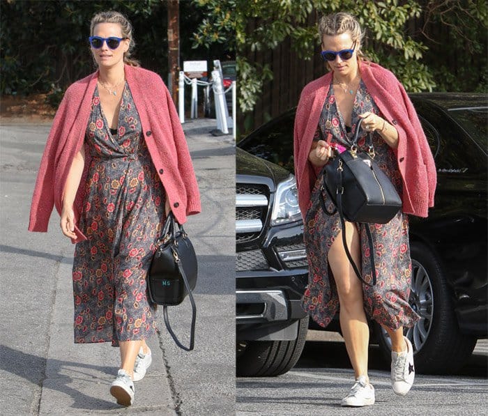 Molly Sims in Brentwood wearing a split floral dress with a pink cardigan draped over her shoulders