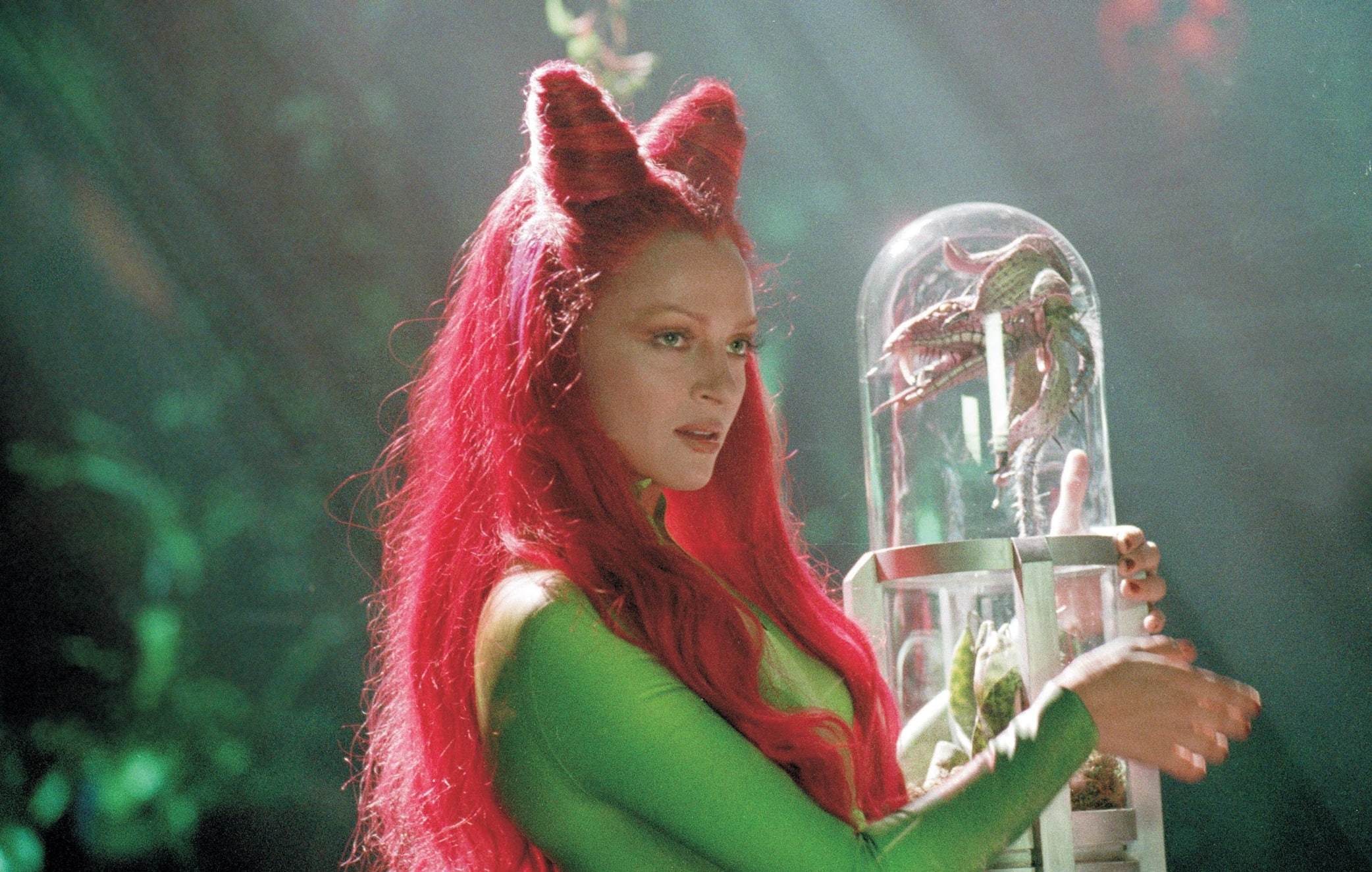 Uma Thurman embodies the seductive and dangerous Poison Ivy as she carefully handles a plant specimen in the 1997 film Batman & Robin