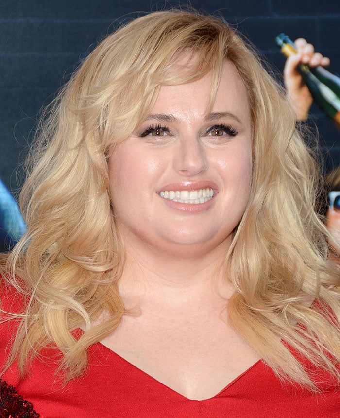 Rebel Wilson wears dramatic eye makeup and peach lipstick on the red carpet