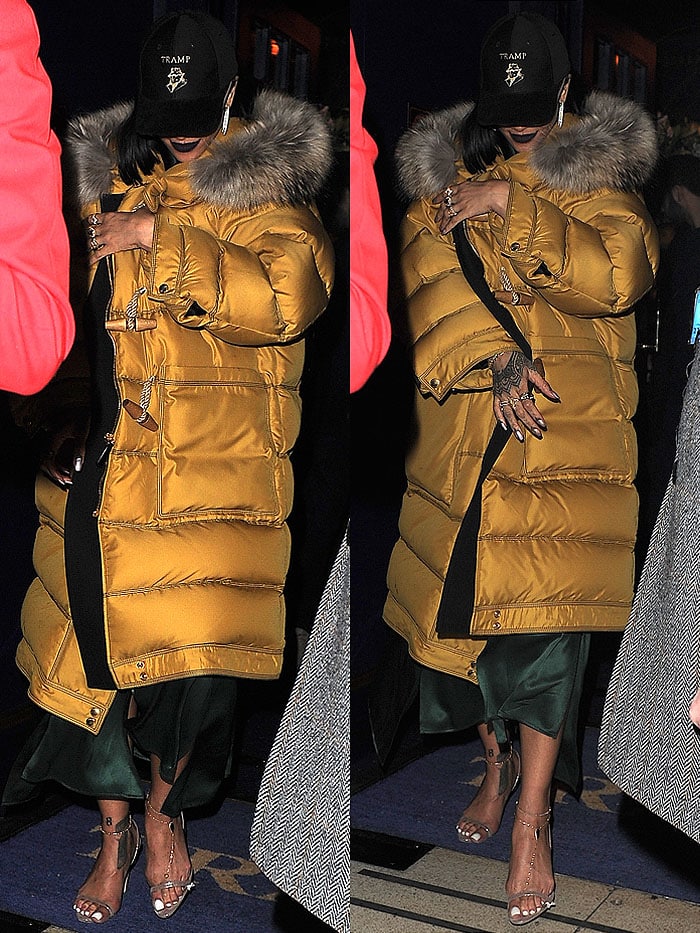 Rihanna covered up her forest-green satin dress and Brian Atwood slingback sandals ensemble with a yellow Burberry fox-fur-trim down-filled duffle coat and a black Tramp nightclub cap on her head