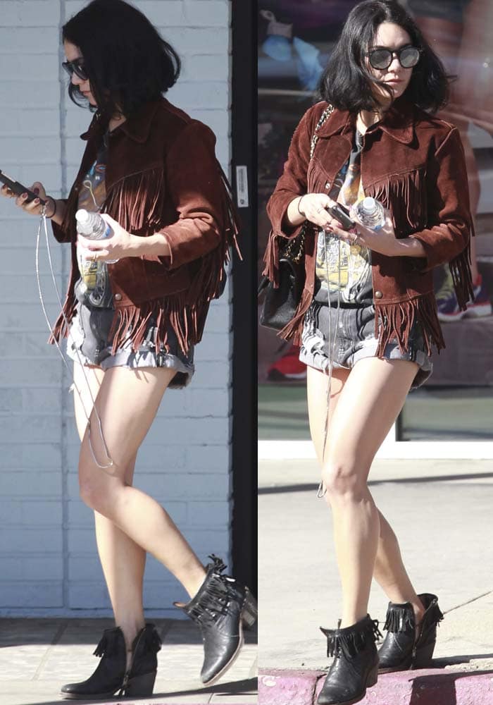 Vanessa Hudgens exudes boho-chic vibes in a Polo Ralph Lauren fringed suede jacket, One Teaspoon 'Outlaws' shorts, Wildfox Steff Deluxe sunglasses, and black fringed ankle boots, accessorized with a Chanel 2.55 flap bag