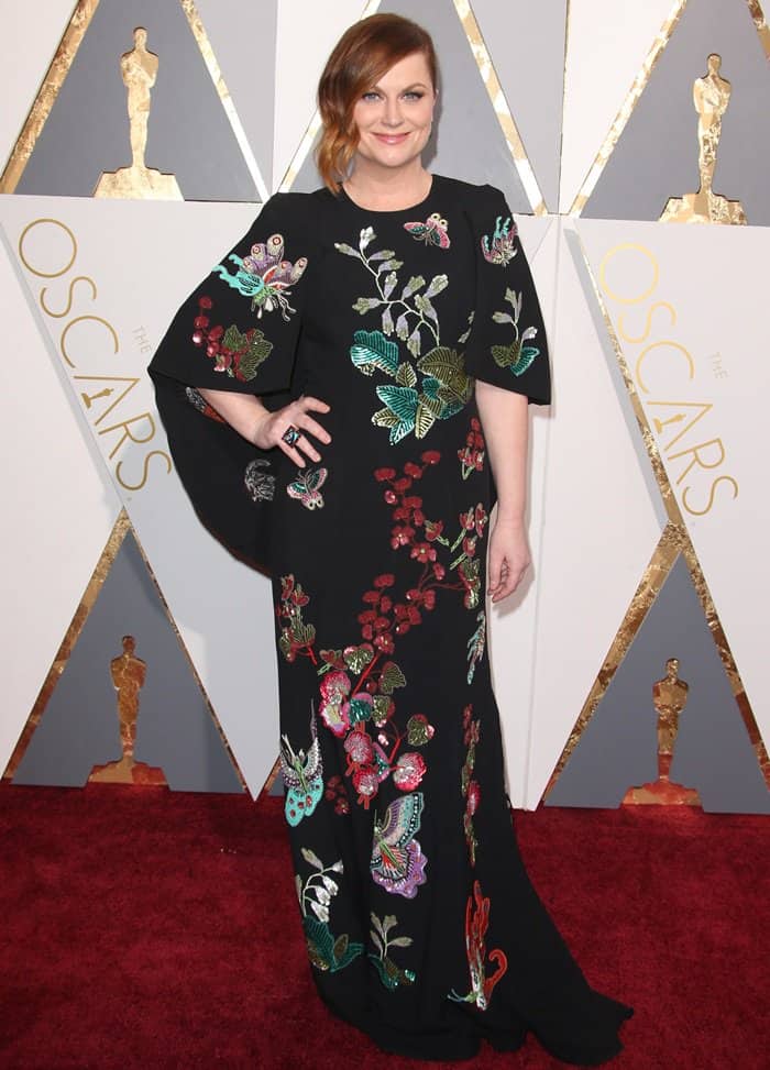 Amy Poehler brings a touch of spring to the red carpet in a vibrant, embroidered André Gn gown at the 88th Annual Academy Awards