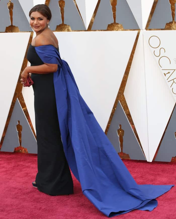Mindy Kaling pairs a black Elizabeth Kennedy gown with a bold blue train at the 88th Annual Academy Awards, creating a striking yet slightly restrictive look