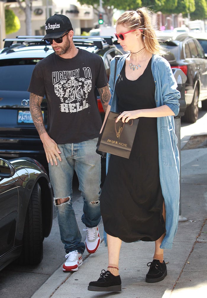 Behati Prinsloo wears a denim duster coat from her collaboration with Juicy Couture over a black maxi dress