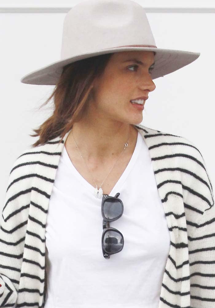 Alessandra Ambrosio covers her hair with a wide-brimmed hat as she leaves Au Fudge with her children