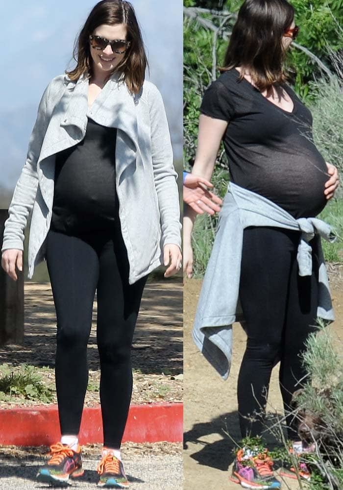 Anne Hathaway wears a black shirt and leggings while on a hike