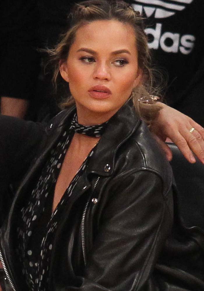 Chrissy Teigen braids her hair for the Los Angeles Lakers game against the Cleveland Cavaliers