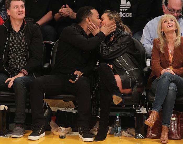 John Legend and Chrissy Teigen kiss for the kiss cam at a Los Angeles Lakers game
