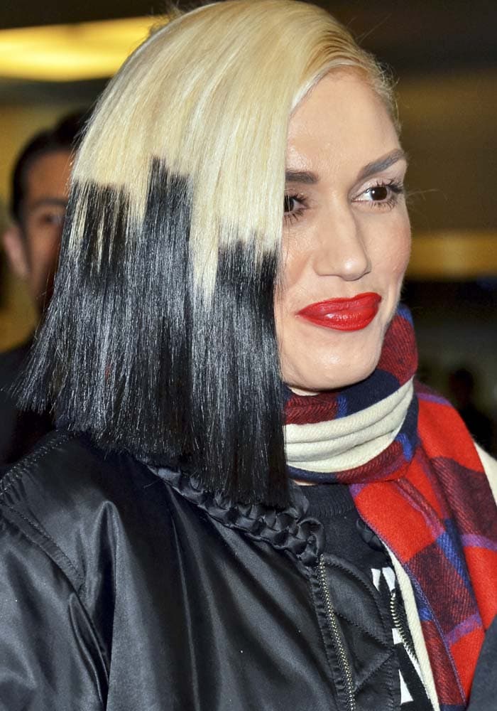 Gwen Stefani shows off her blonde-and-black hair as she arrives at Haneda Airport in Tokyo