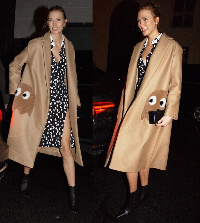 Karlie Kloss wears an Anya Hindmarch coat featuring quirky Pacman ghost motif pocket detailing, oversized fit, long sleeves, and a flattering silhouette