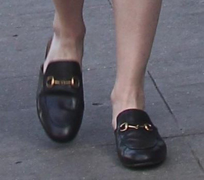 Kirsten Dunst's feet in black leather Gucci Princetown mule loafers