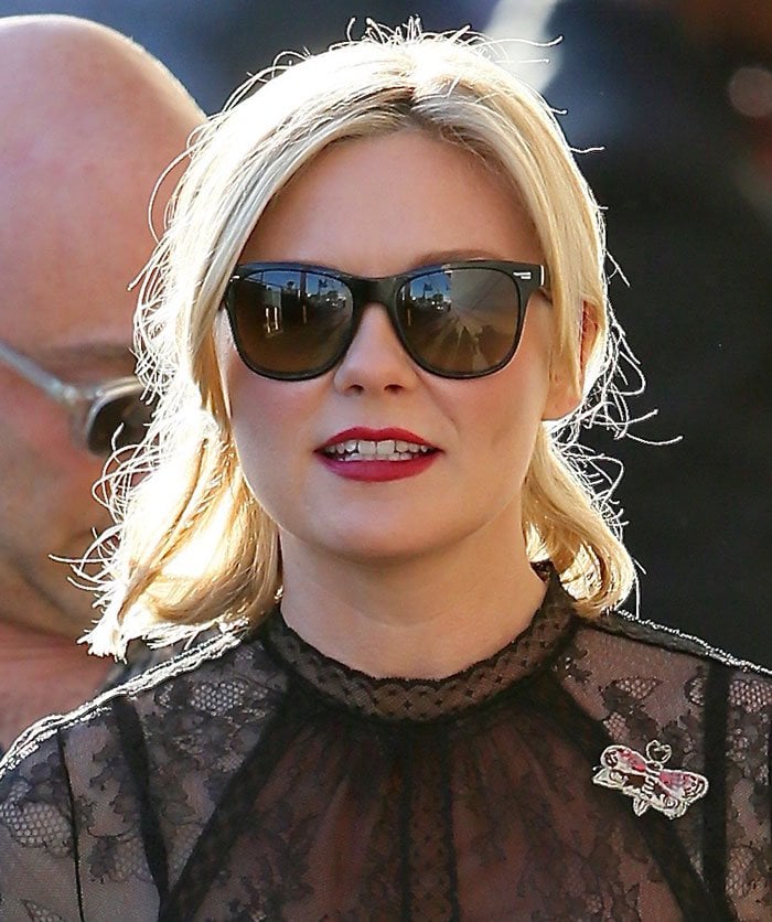 Kirsten Dunst clips her hair back as she arrives at the Los Angeles ABC Studios for "Jimmy Kimmel Live!"