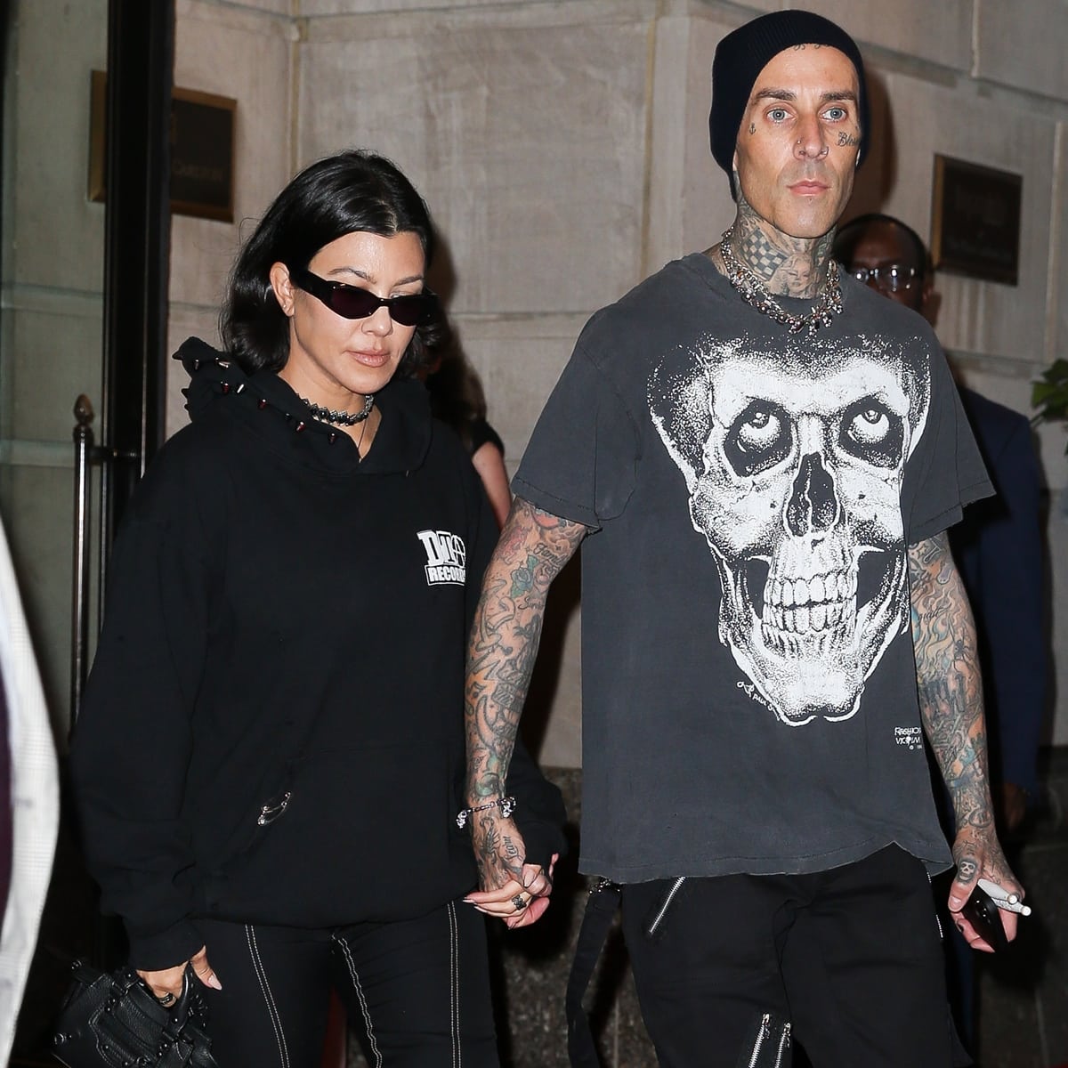 Kourtney Kardashian and Travis Barker hand-in-hand leaving their hotel in NYC