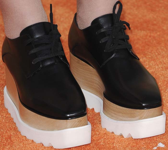 Meghan Trainor wears a pair of Stella McCartney platform sneakers on the orange carpet