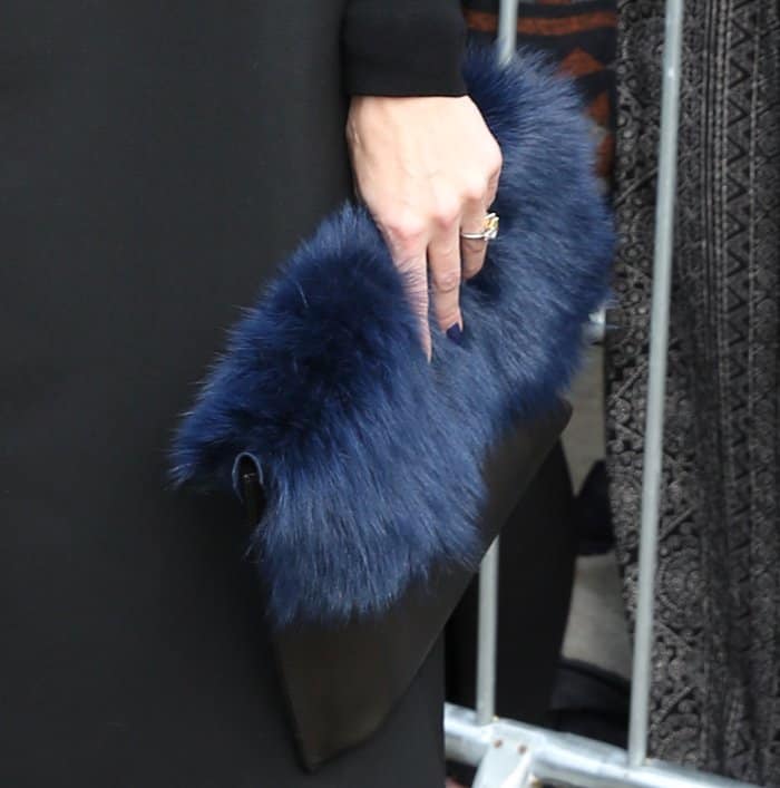 Olivia Palermo's clutch is a sophisticated black leather piece adorned with a luxurious blue fur trim