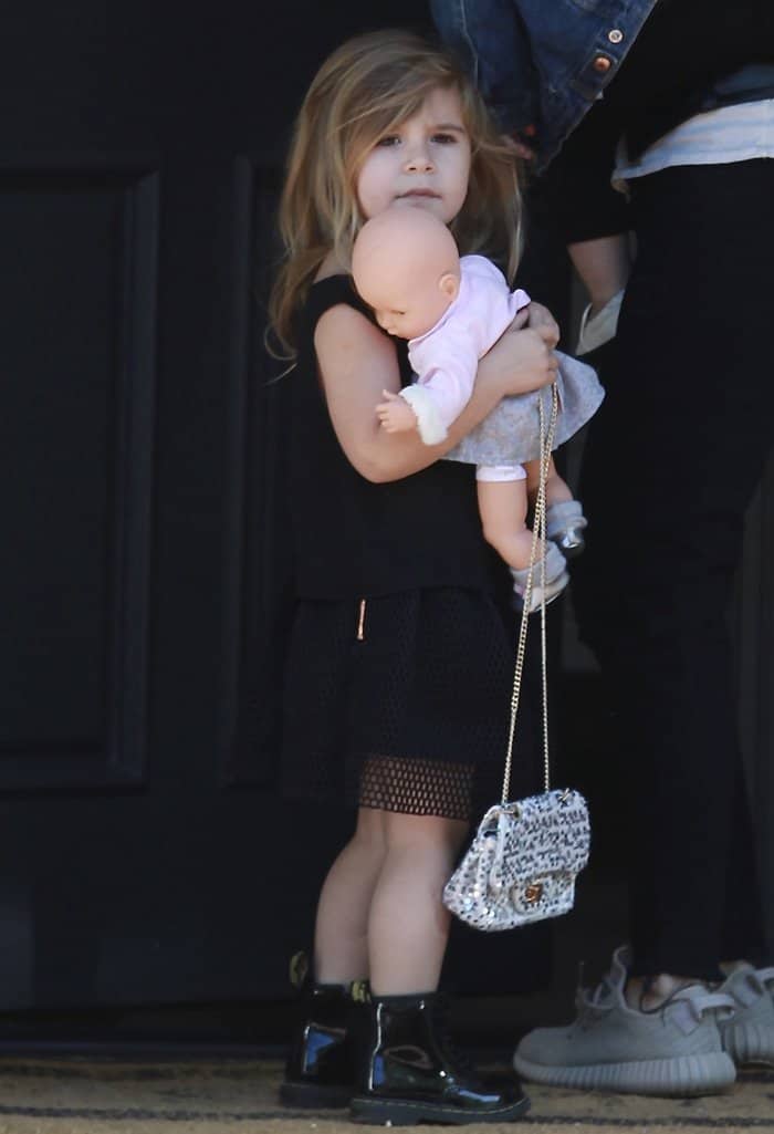 Penelope Disick looks adorable and stylish outside her home on February 18, 2016, heading to singing class in an all-black ensemble featuring a mesh skirt, glossy patent boots, and a chic mini Chanel handbag