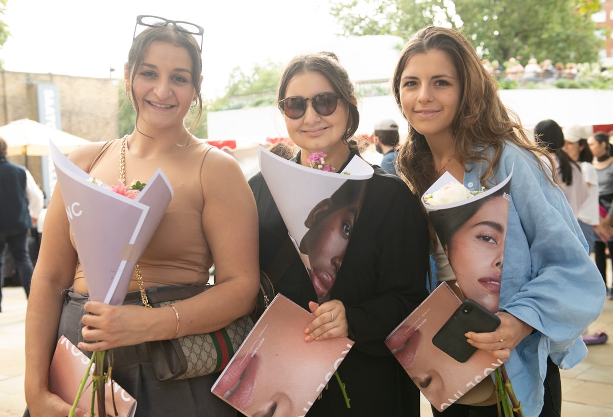 Visitors pose with their free flowers at a pop-up flower stall for Rose Inc, the make-up and skincare range of model/actress Rosie Huntington-Whiteley, to coincide with the placement of Rose Inc products at Space NK's nearby store