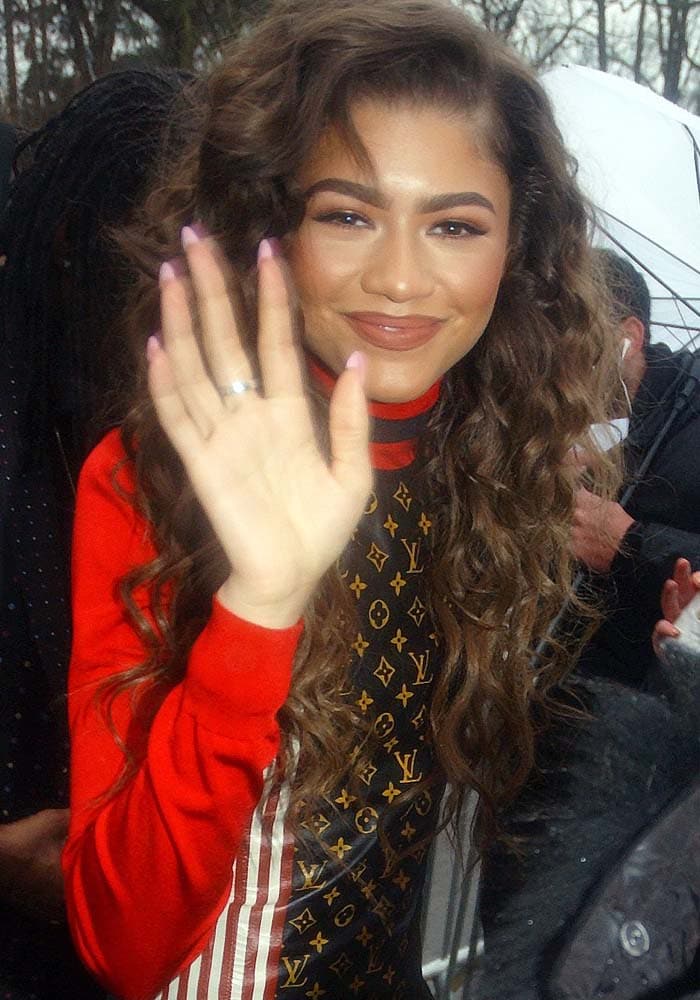 Zendaya smiles and waves after being accidentally hit with an umbrella