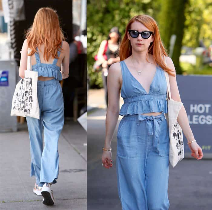 Emma Roberts keeps it casual and cool with her loose red hair, chic sunglasses, and a stylish printed tote bag, perfectly complementing her light blue chambray jumpsuit