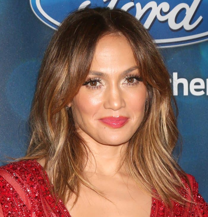 Jennifer Lopez wore her hair in soft, voluminous waves, perfectly framing her face, and her makeup featured a glowing complexion, shimmering eyeshadow, bold lashes, and a pop of pink on her lips