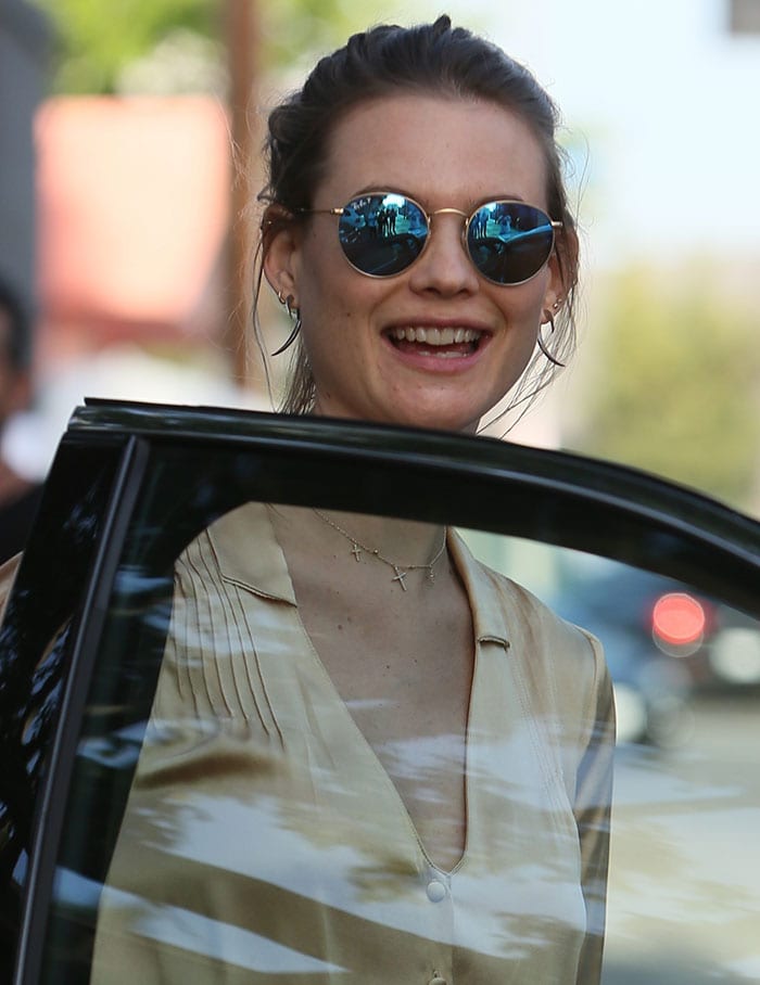 Behati Prinsloo smiles at the paparazzi as she opens her car door