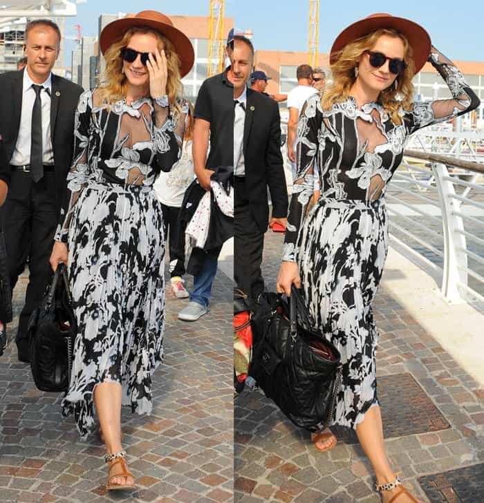 Diane Kruger effortlessly blends bohemian femininity with modern elegance in a sheer, floral-print dress, accessorized with a wide-brim hat and sandals while strolling in Venice