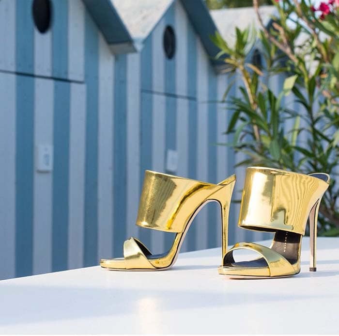 These Andrea sandals are designed with a glossy and metallic gold-tone hue and finished with a sleek and high stiletto heel