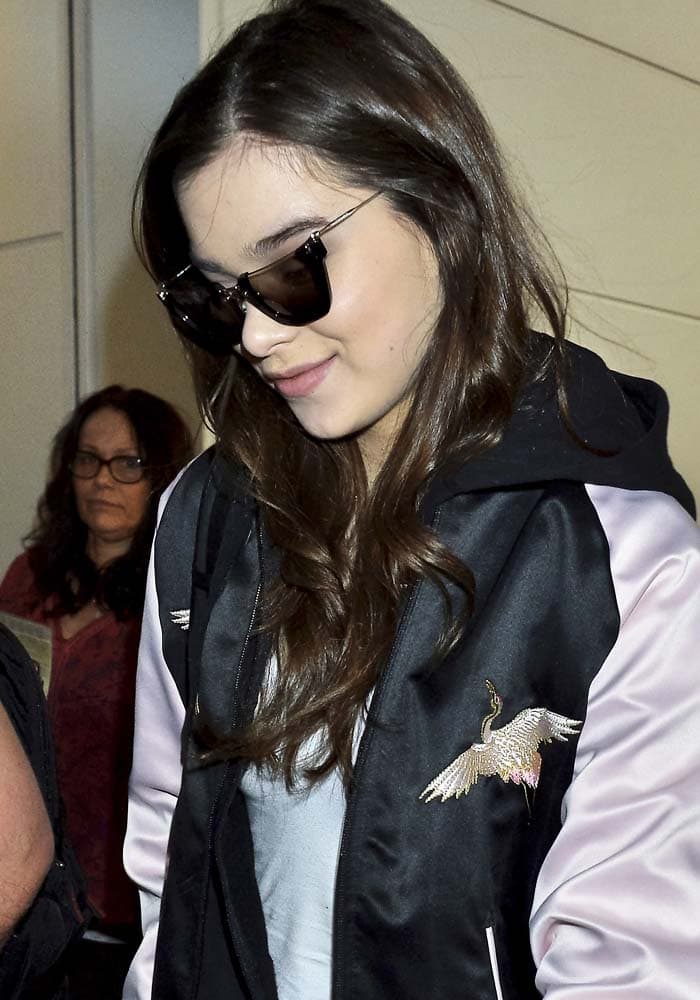 Hailee Steinfeld wears her hair down as she arrives at Haneda Airport