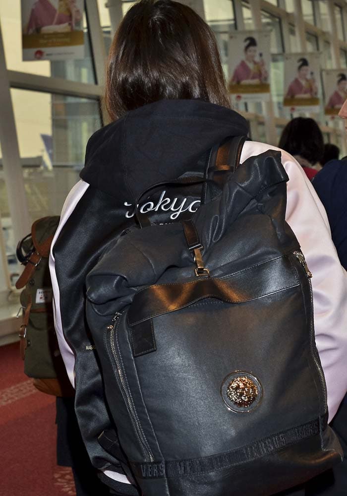 Hailee Steinfeld carries a Versus Versace backpack over her Adidas "Tokyo" track jacket