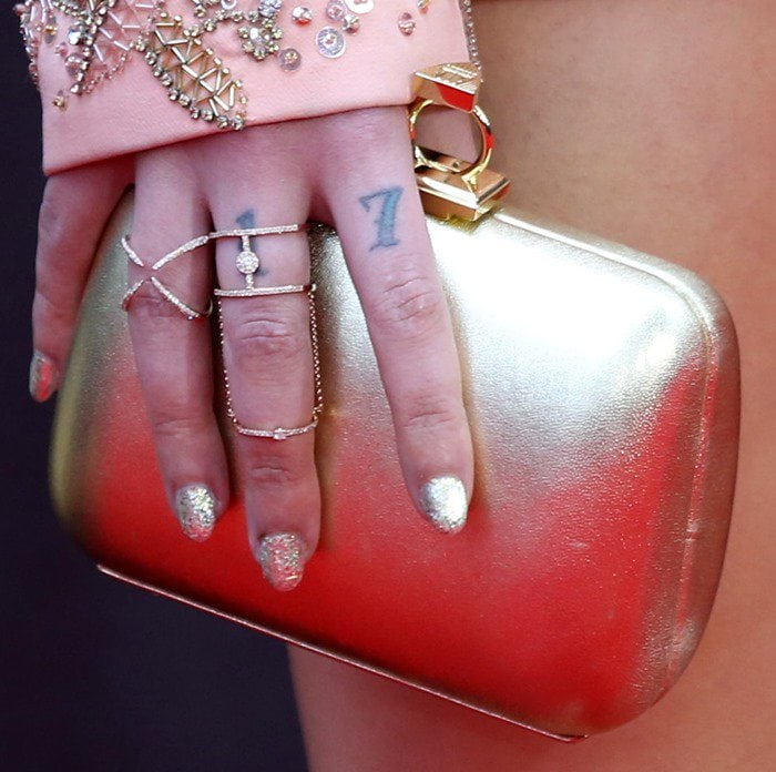 Halsey totes a gold leather Loriblu clutch with jewel claps