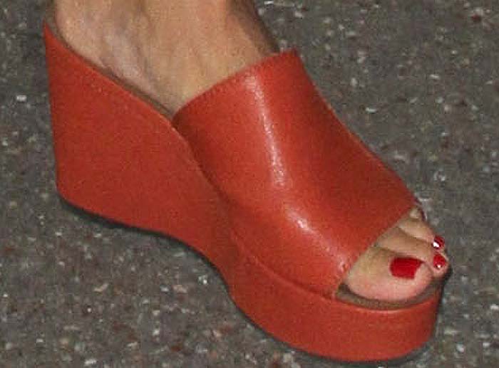 Heidi Klum slips into a pair of orange flatforms