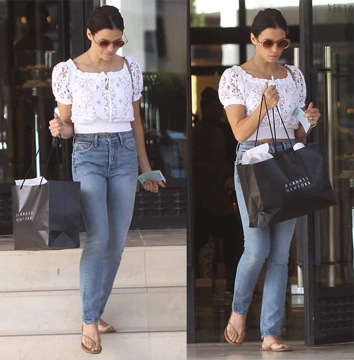 Jenna Dewan Tatum effortlessly rocks a chic, casual look in a white eyelet crop top, high-waisted jeans, and flip-flops while shopping at Barneys New York