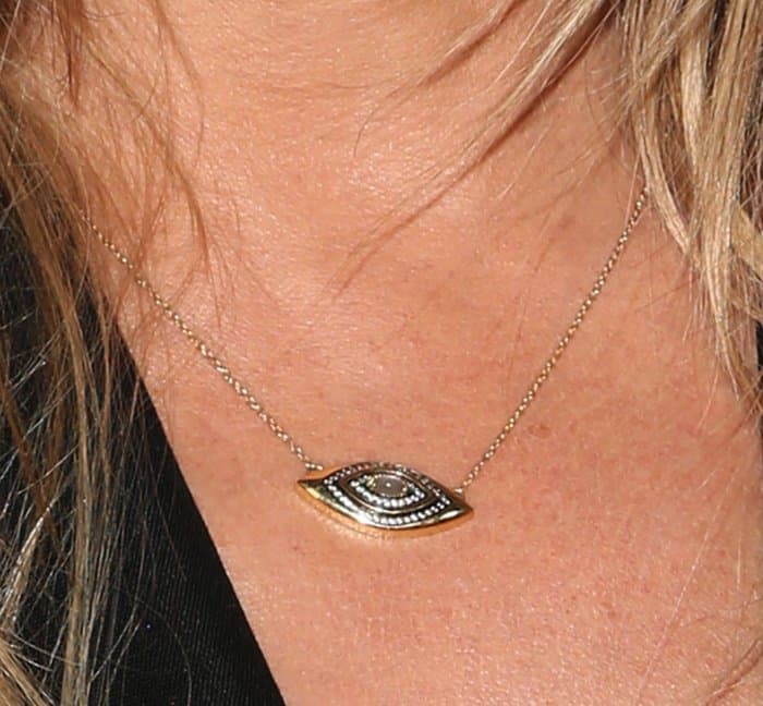 Close-Up Charm: A detailed view of Jennifer Aniston's captivating evil eye necklace, a blend of fashion and folklore
