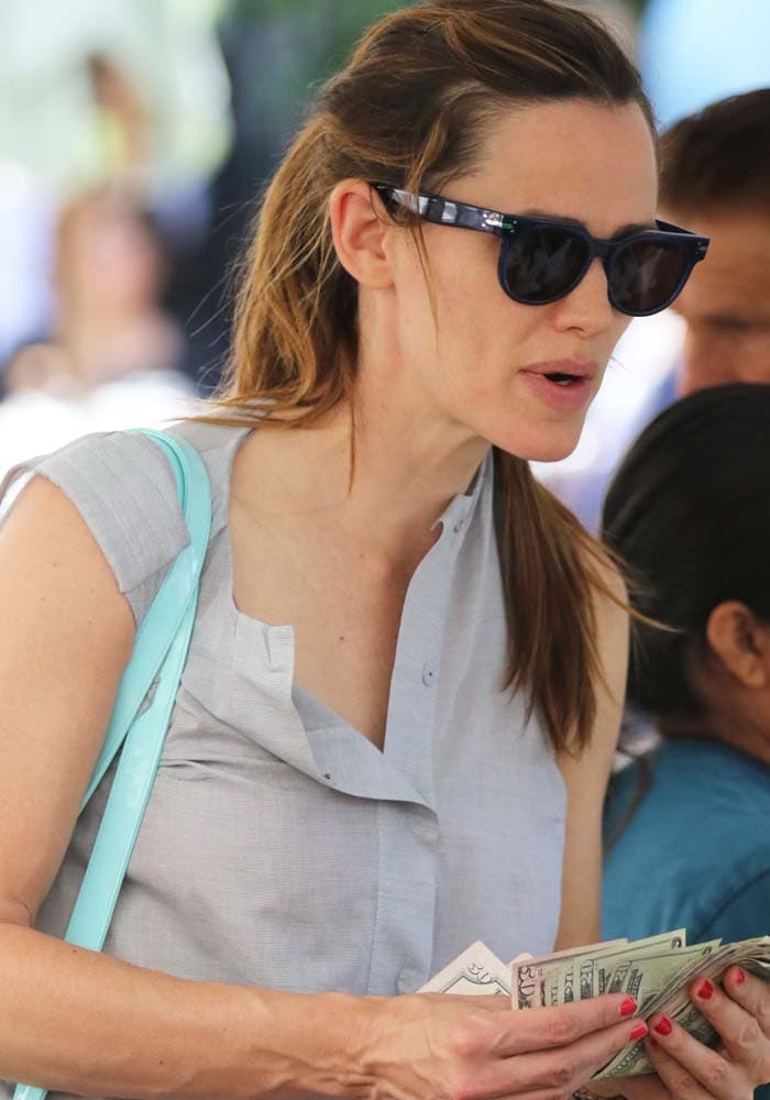 Jennifer Garner holds a wad of dollar bills as she shops at the Farmers Market