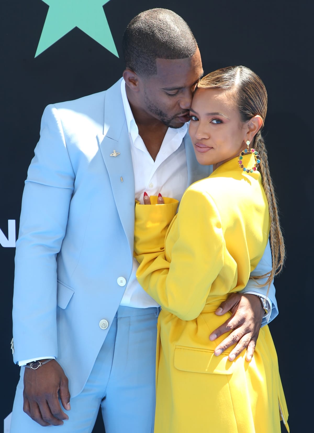 Karrueche Tran wears a House of Holland suit as she poses with boyfriend Victor Cruz at the 2019 BET Awards