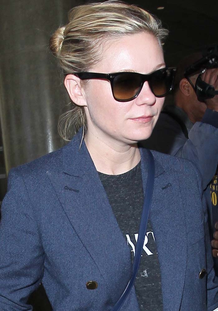 Kirsten Dunst wears her hair in a bun as she arrives at Los Angeles International Airport