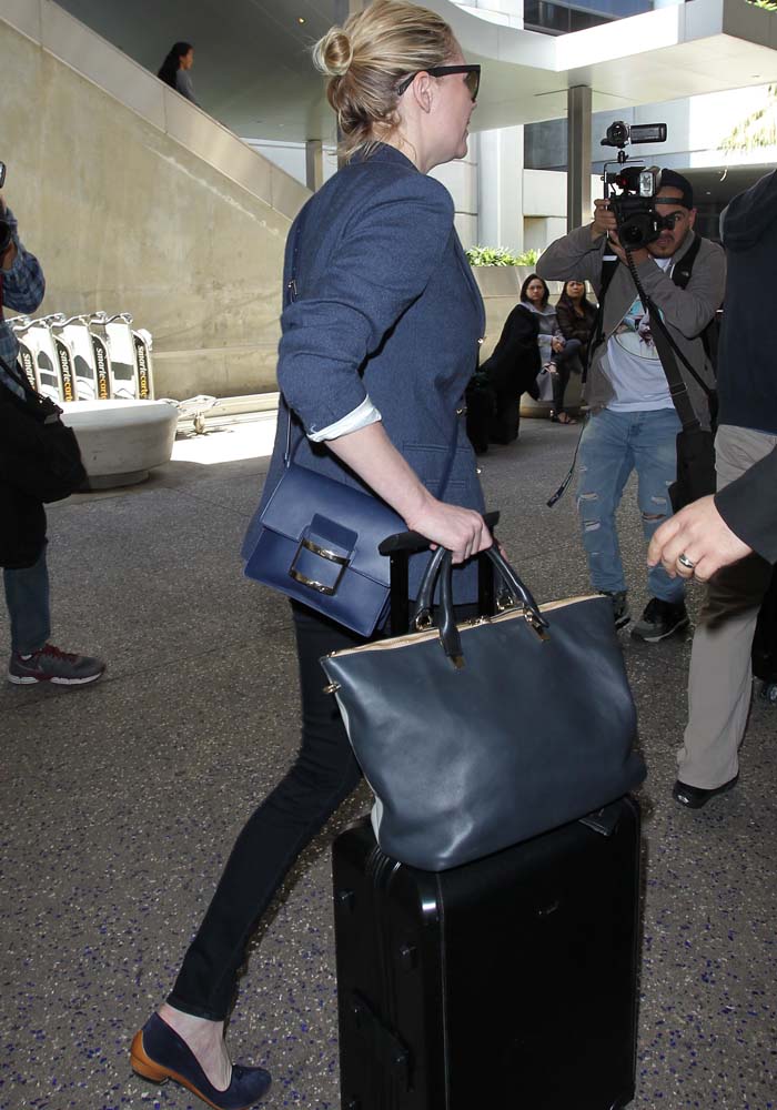 Kirsten Dunst matches her navy ensemble to her navy luggage