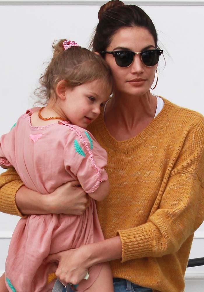 Lily Aldridge wears her hair up in a bun while holding her daughter Dixie Pearl Followill and leaving Au Fudge