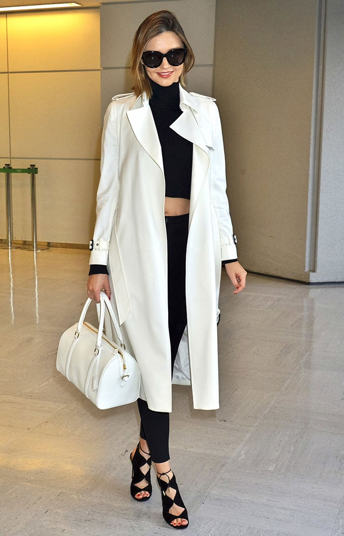 Miranda Kerr wears a Barneys New York trench coat as she strolls through LAX