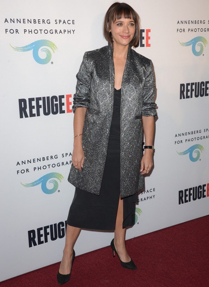 Rashida Jones opts for a metallic Suno blazer layered over a simple black dress, though the structured jacket overwhelms the look rather than enhancing it