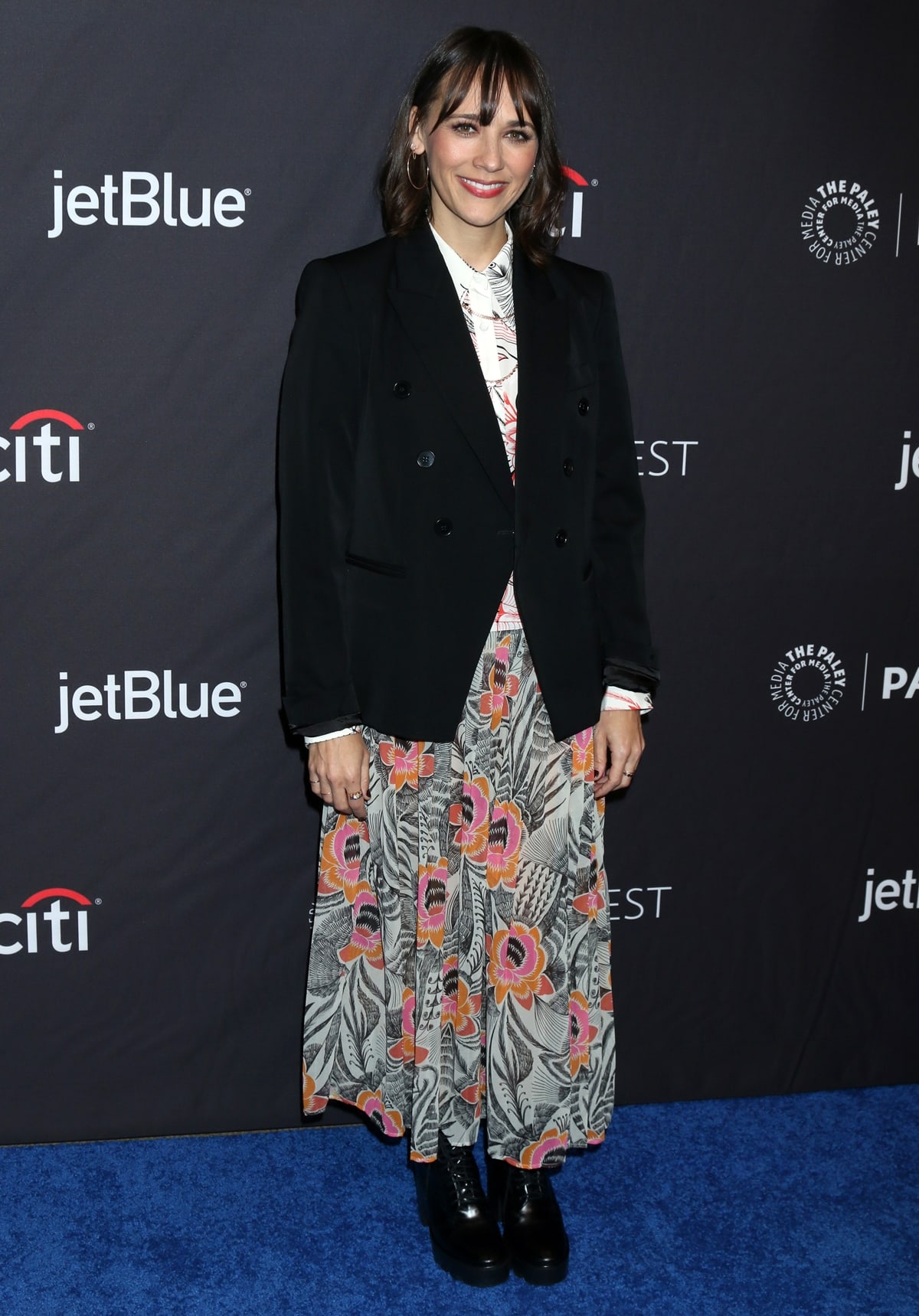 Rashida Jones in a black jacket paired with a floral skirt and combat boots at The Paley Center For Media's 2019 PaleyFest LA - "Parks And Recreation" 10th Anniversary Reunion