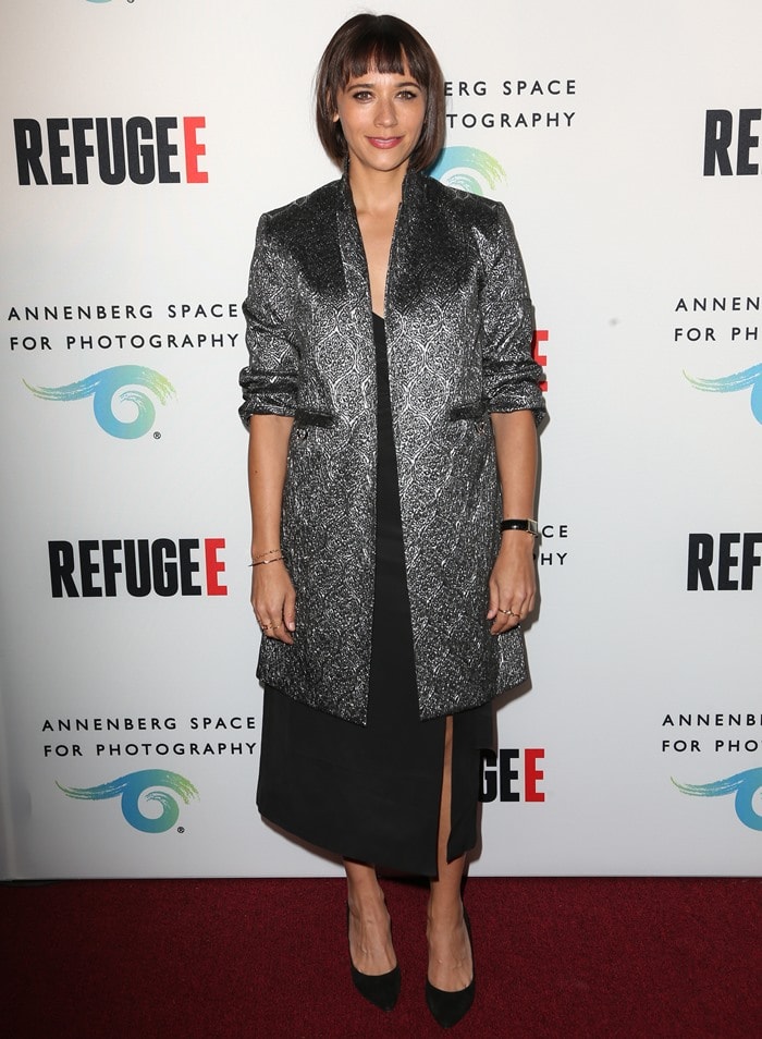 Rashida Jones wears a long metallic blazer over a long black dress on the red carpet