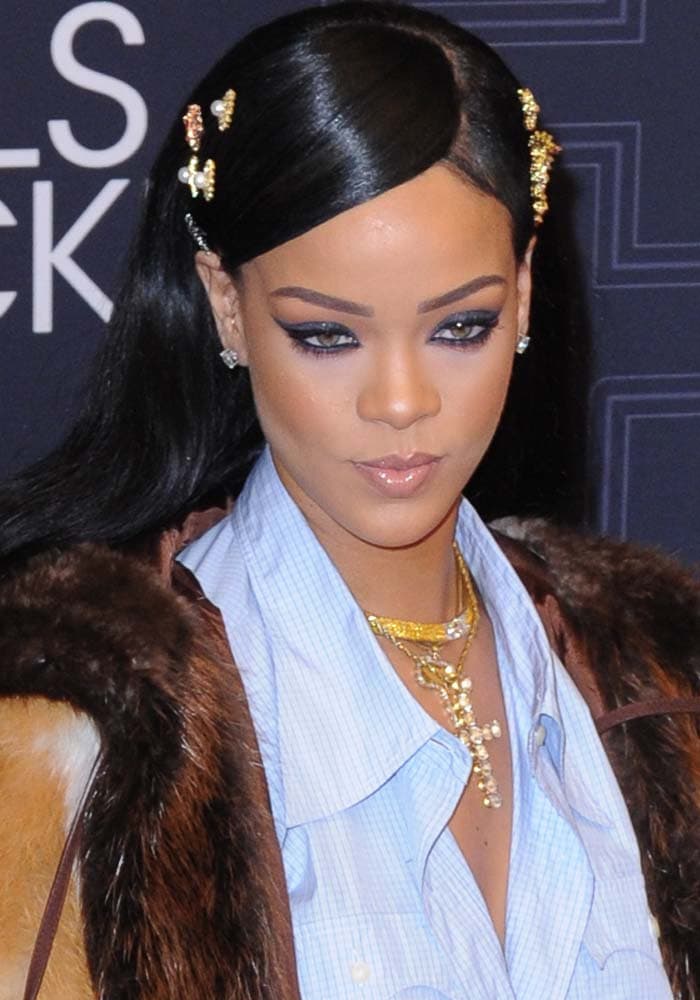 Rihanna stuns in a blue button-up shirt and fur coat, accessorized with golden hairpins and a dazzling Le Vian diamond cross necklace at the BET Black Girls Rock! Awards