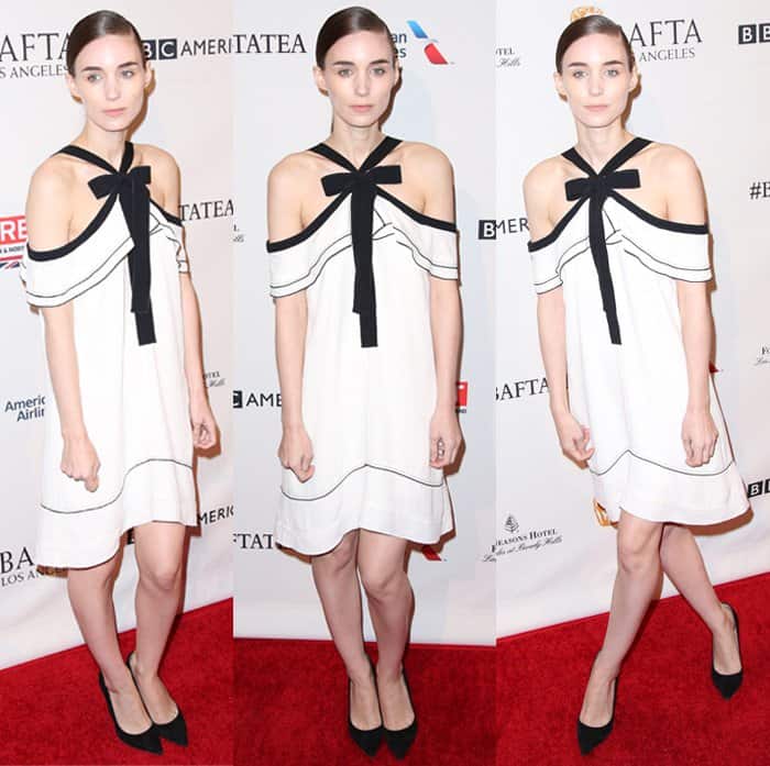Rooney Mara channels modern femininity in a chic off-shoulder white dress with black accents, effortlessly blending playful and elegant elements on the red carpet