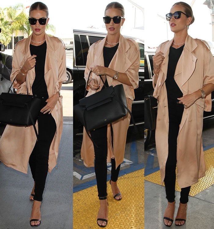 Rosie Huntington-Whiteley wears skinny black pants, a black tee and a drapey trench coat at the airport